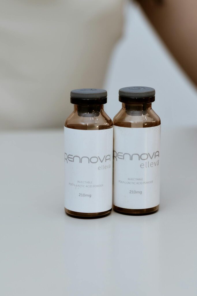 Brown glass bottles with 'Renova Elleva' label on a white table. Clean and minimal.